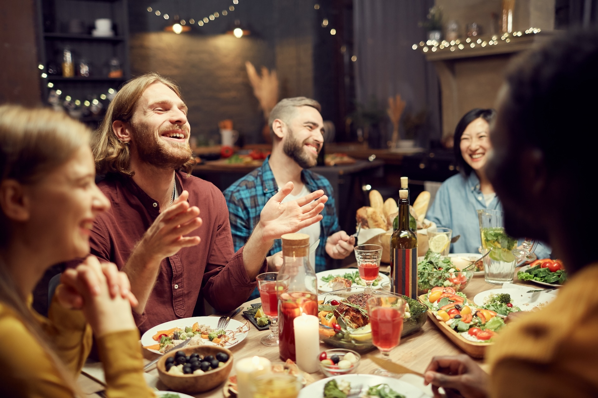 Group of emotional young people enjoying dinner