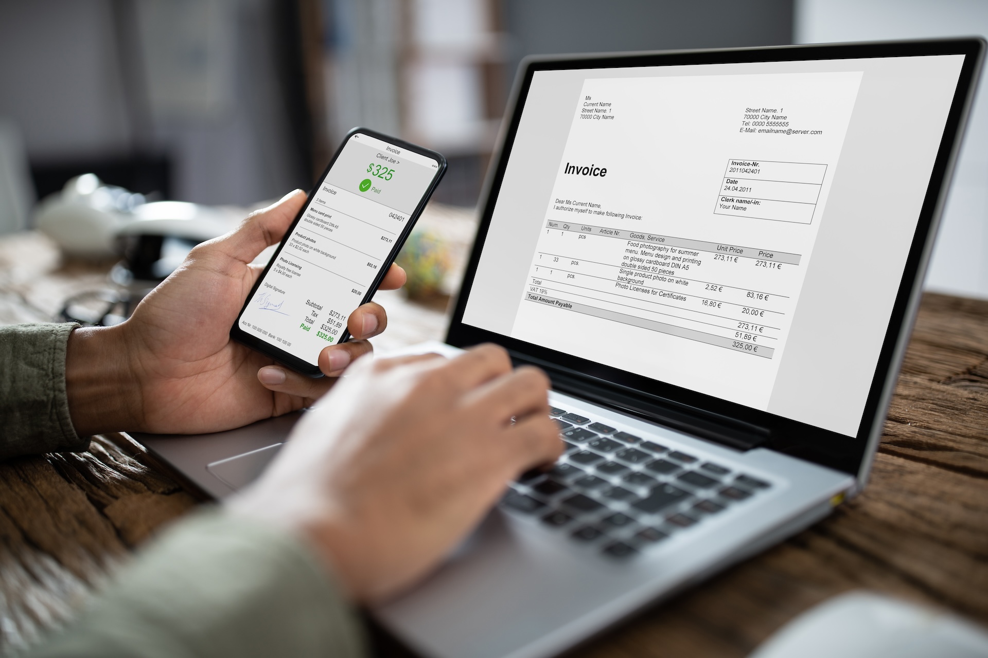 Businessman's Hands Working On Invoice On Laptop