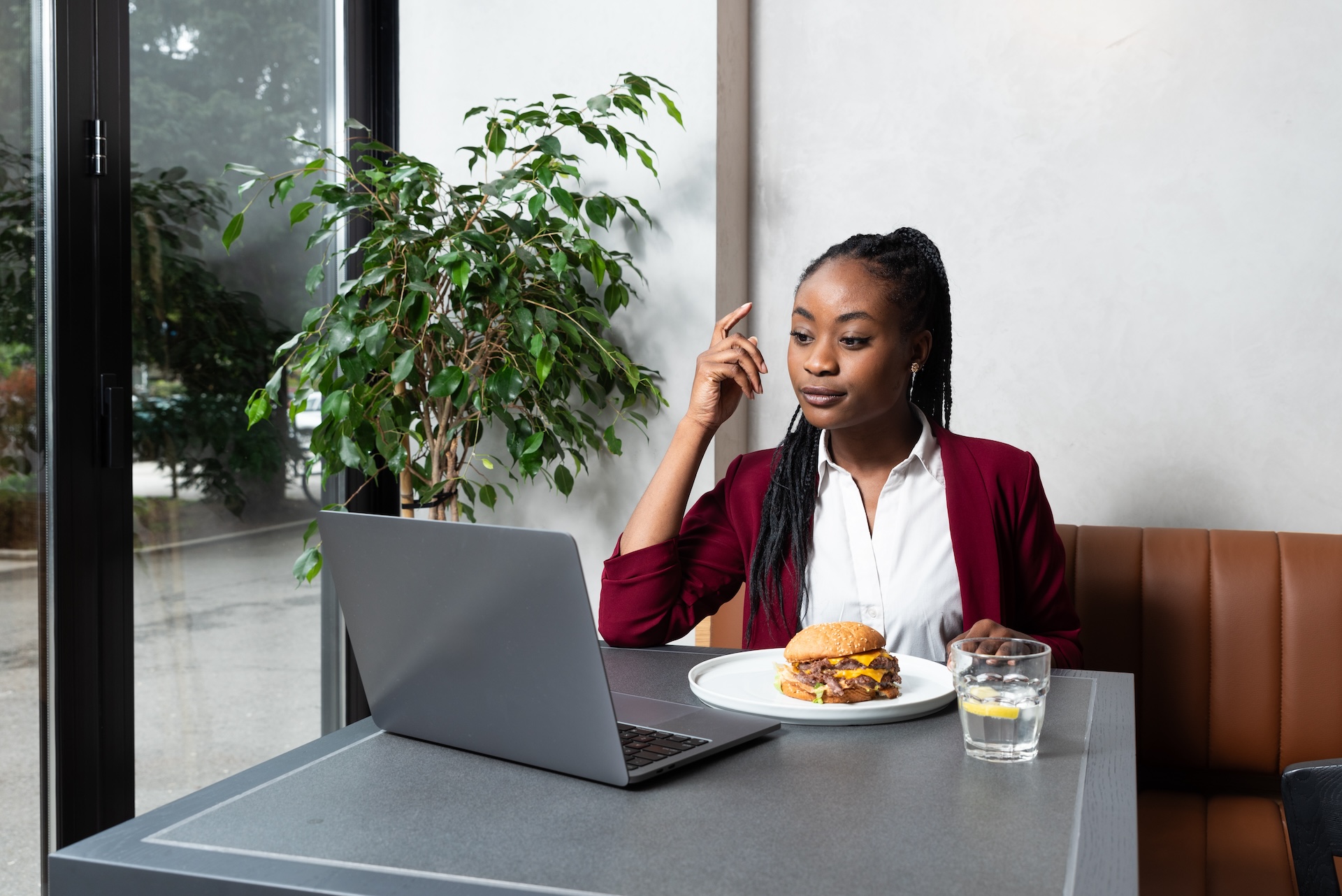 business woman sitting at a quick service restaurant using laptop for online work