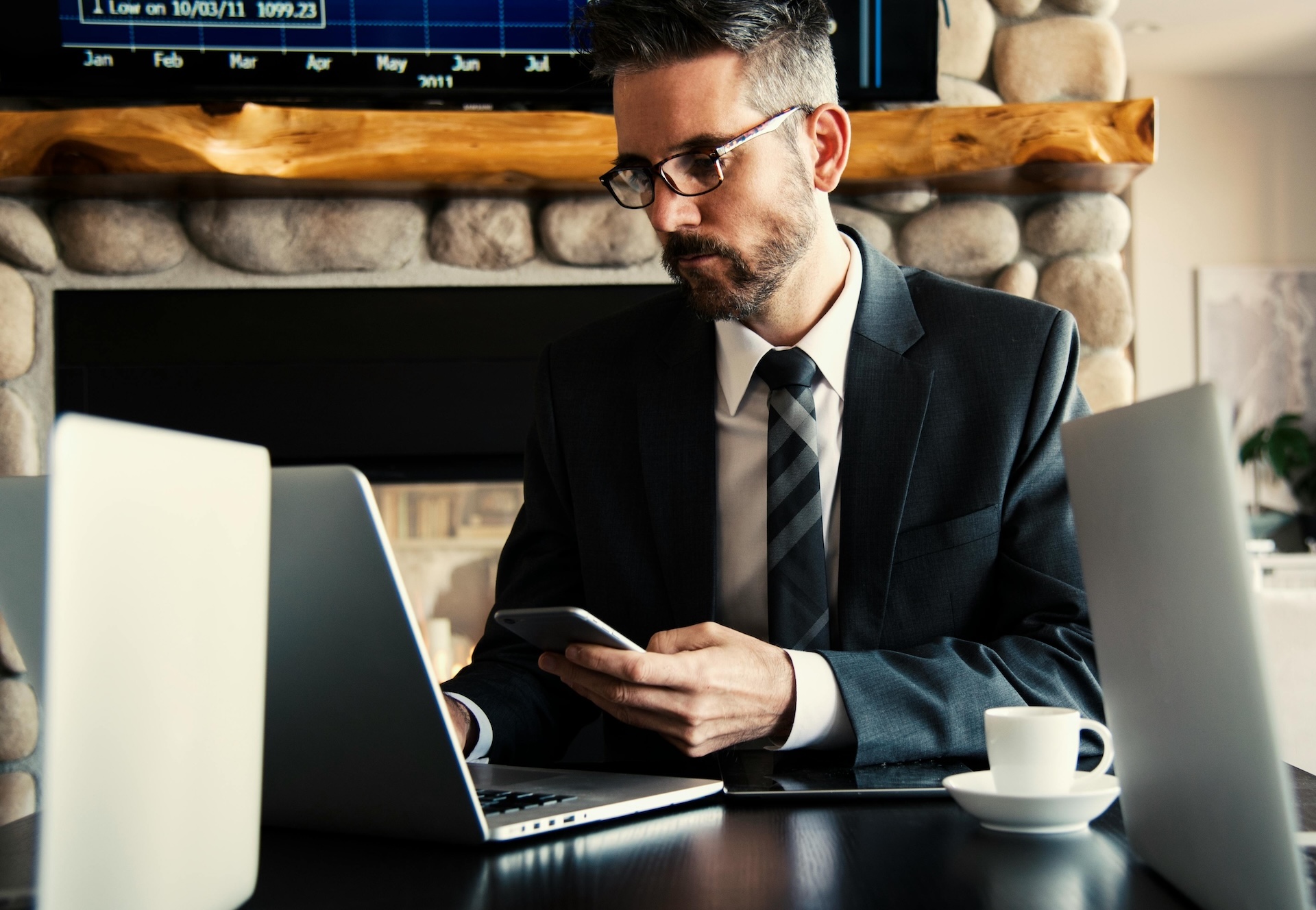 man working on the functions of financial management holding phone